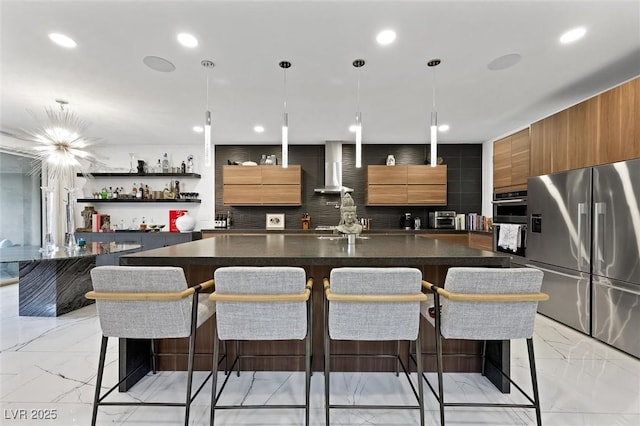 kitchen with marble finish floor, stainless steel appliances, wall chimney exhaust hood, and modern cabinets