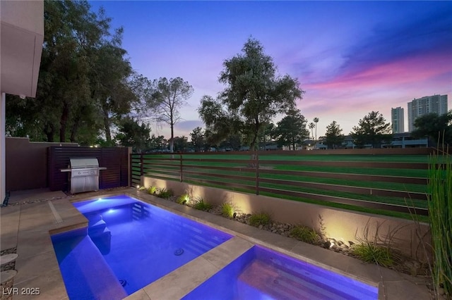 view of pool with fence and area for grilling