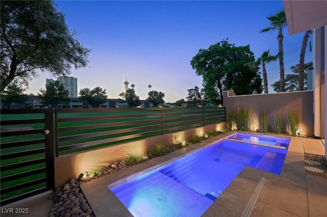 view of swimming pool with fence and an in ground hot tub