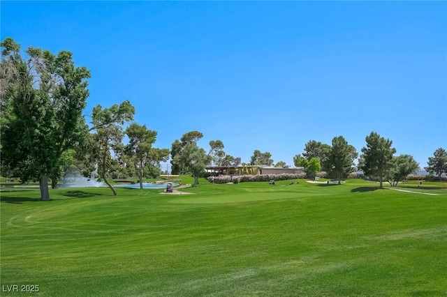 view of property's community with view of golf course and a lawn