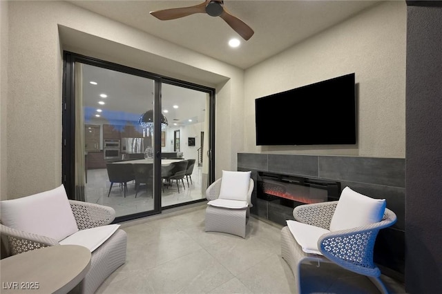 living area featuring ceiling fan, a textured wall, and recessed lighting