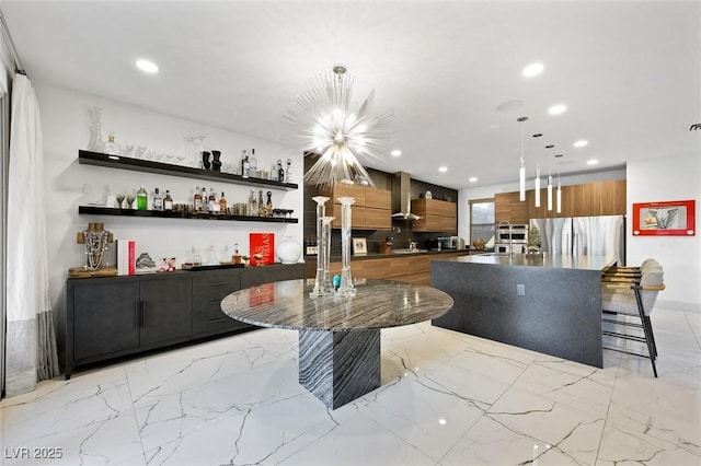 interior space featuring marble finish floor, decorative light fixtures, freestanding refrigerator, and recessed lighting