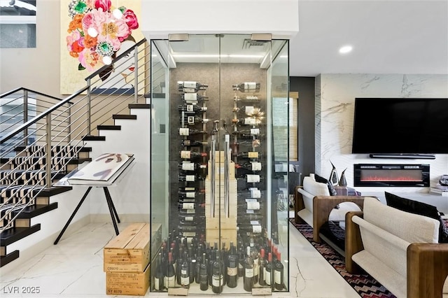 wine area with marble finish floor, a premium fireplace, and recessed lighting