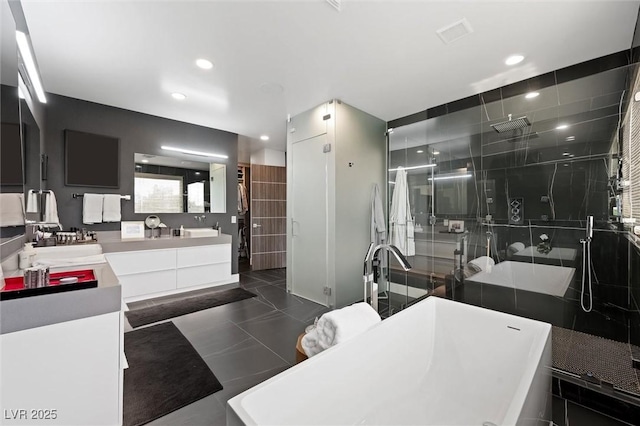 full bathroom featuring tile patterned floors, a freestanding bath, a shower stall, and double vanity