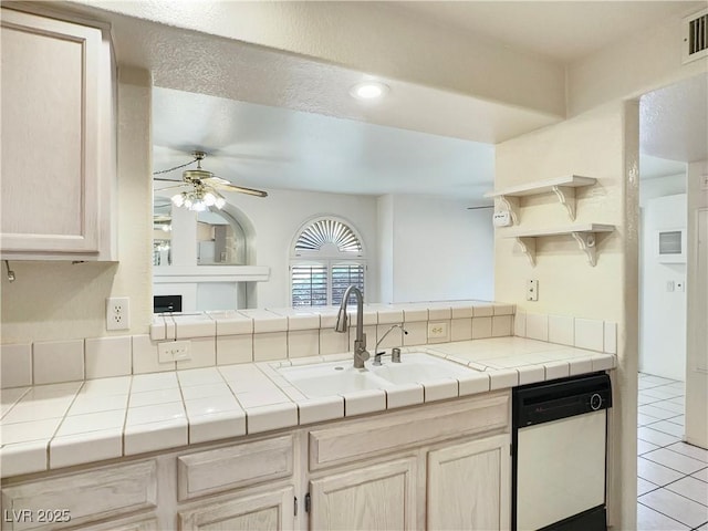 kitchen with a ceiling fan, dishwasher, tile countertops, and a sink