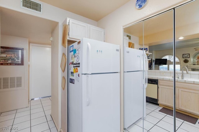 kitchen with tile counters, visible vents, light tile patterned flooring, a sink, and white appliances