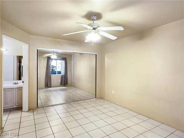 empty room featuring light tile patterned floors and ceiling fan