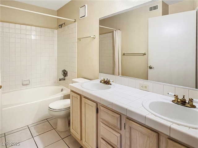 bathroom with toilet, tile patterned flooring, a sink, and visible vents