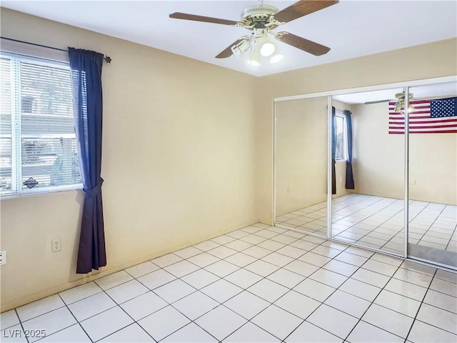 empty room featuring light tile patterned floors and ceiling fan