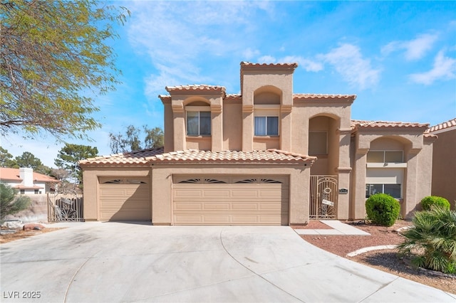 mediterranean / spanish-style home with a gate, a tiled roof, concrete driveway, and stucco siding