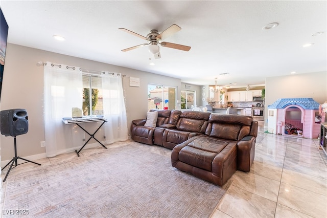 living area with ceiling fan with notable chandelier, baseboards, and recessed lighting