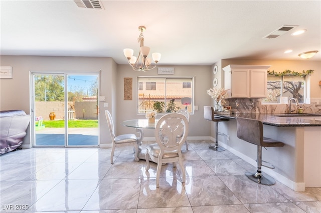 dining room with visible vents, a notable chandelier, and baseboards