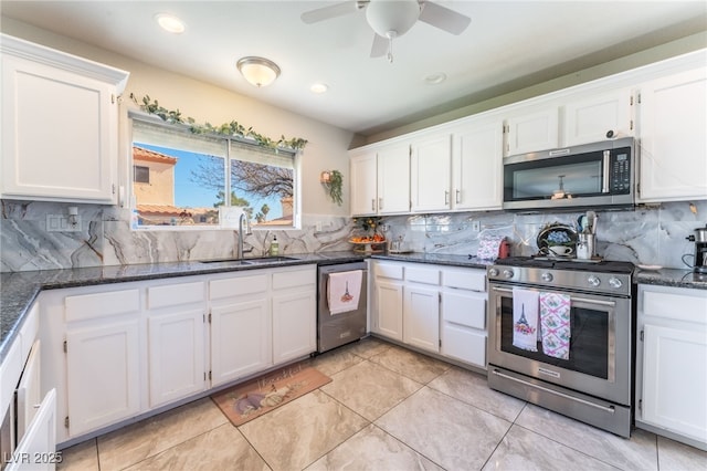 kitchen featuring appliances with stainless steel finishes, white cabinetry, a sink, and backsplash