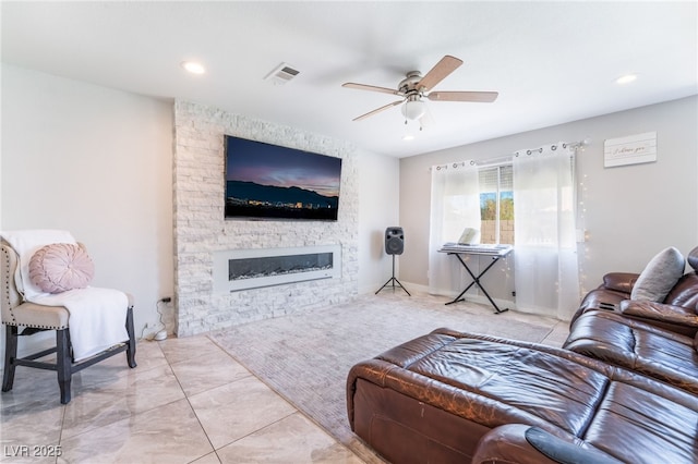 living room featuring recessed lighting, ceiling fan, visible vents, and a stone fireplace