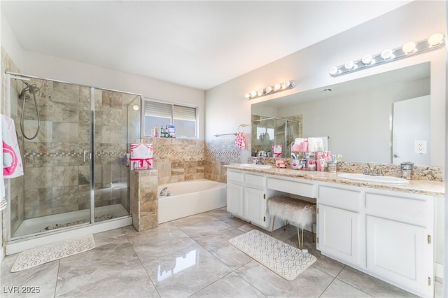 bathroom featuring a garden tub, a sink, a shower stall, and double vanity