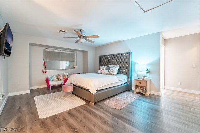 bedroom with ceiling fan, wood finished floors, visible vents, and baseboards