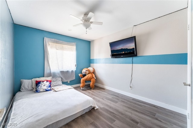 bedroom with ceiling fan, wood finished floors, and baseboards