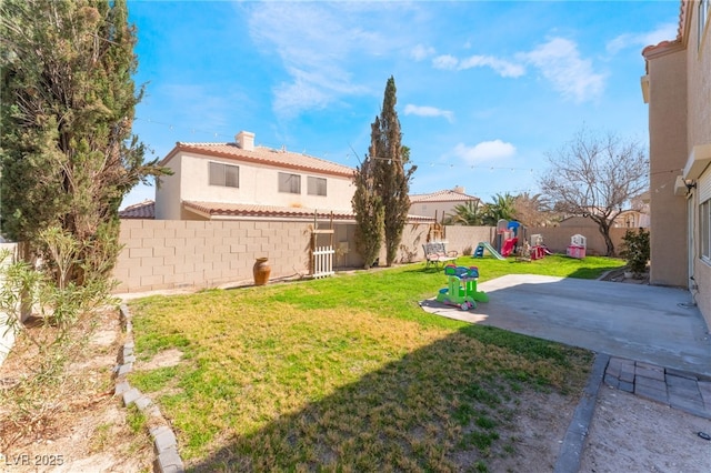 view of yard featuring a fenced backyard, a playground, and a patio