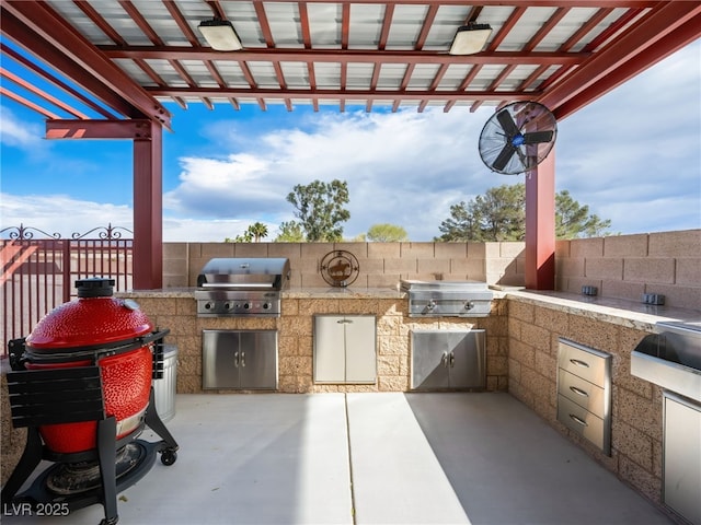 view of patio with a grill, an outdoor kitchen, and fence