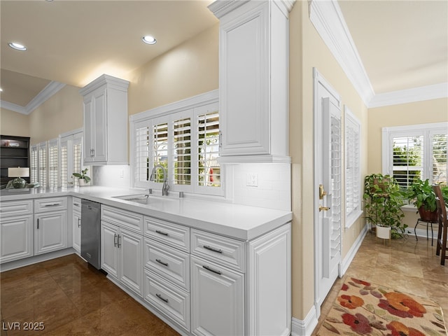 kitchen featuring backsplash, ornamental molding, white cabinets, and a sink