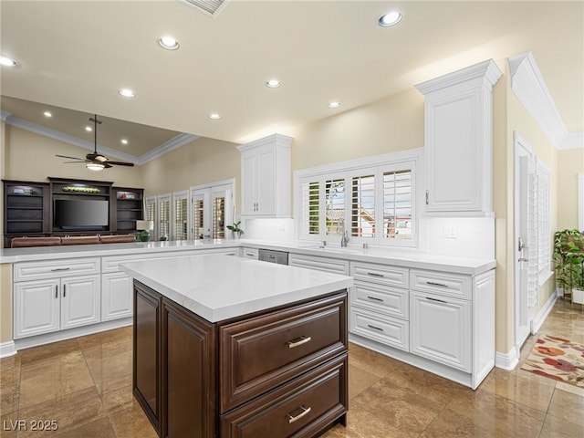 kitchen featuring light countertops, white cabinets, recessed lighting, and a sink