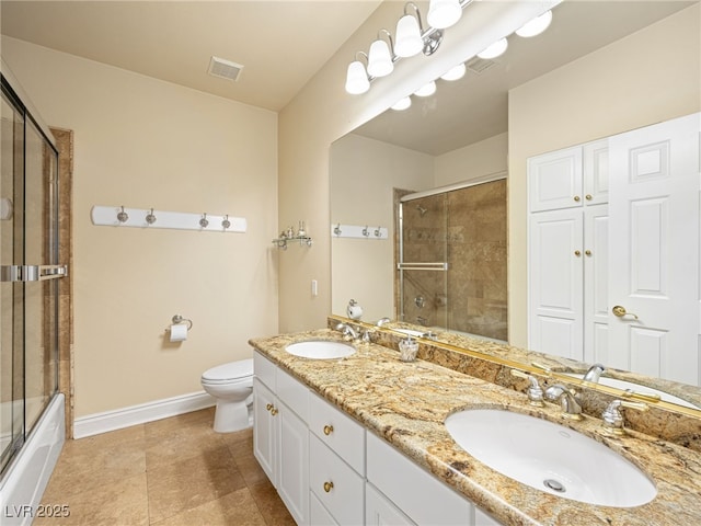 full bath with a sink, baseboards, toilet, and double vanity