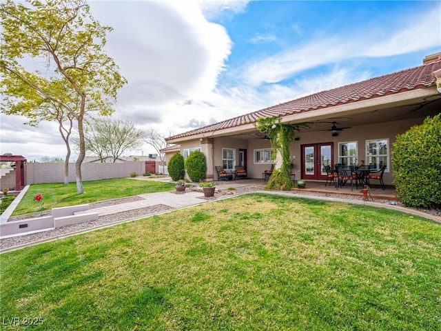 back of property with a ceiling fan, fence, stucco siding, french doors, and a patio area