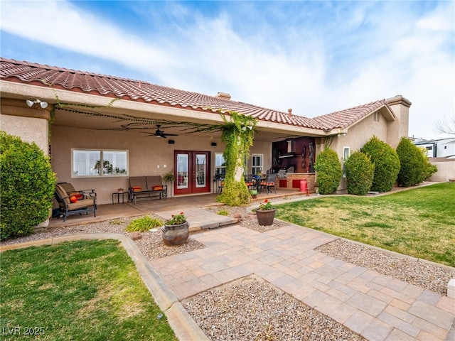 back of property with stucco siding, a patio, a ceiling fan, and french doors