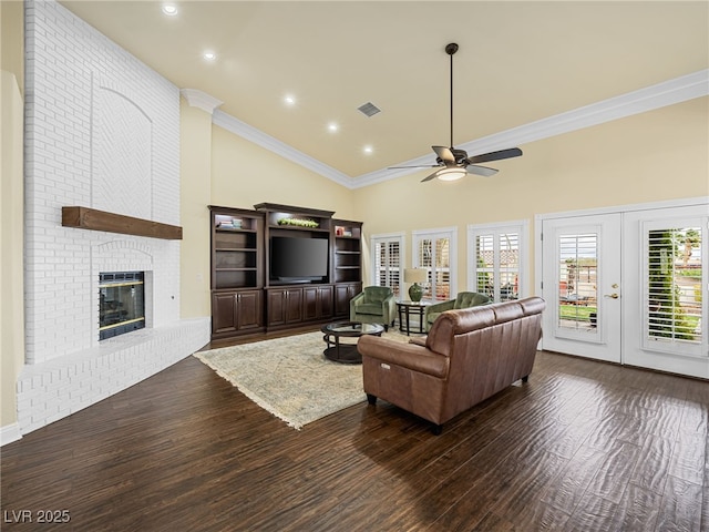 living room featuring visible vents, high vaulted ceiling, ornamental molding, wood finished floors, and a brick fireplace