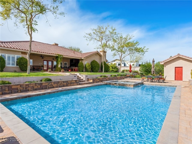 view of swimming pool with a patio, a pool with connected hot tub, and a ceiling fan