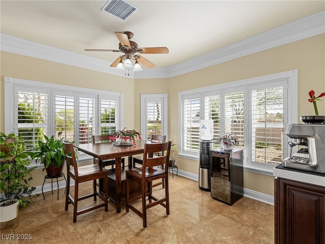 dining space with beverage cooler, visible vents, crown molding, and baseboards