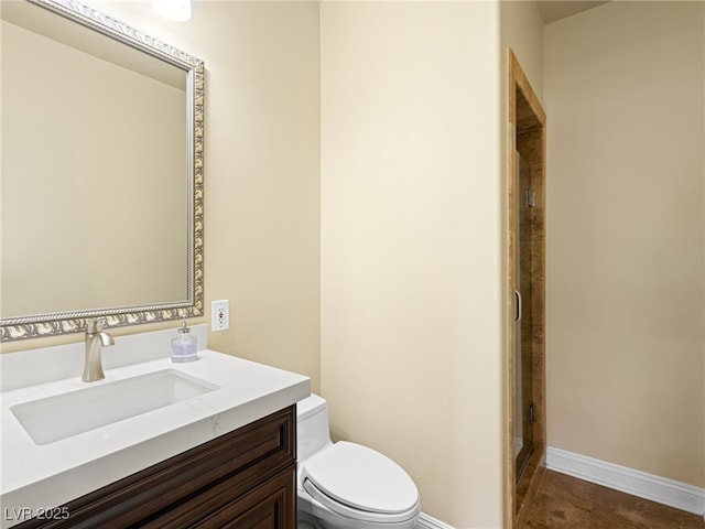 full bath with vanity, toilet, baseboards, and an enclosed shower