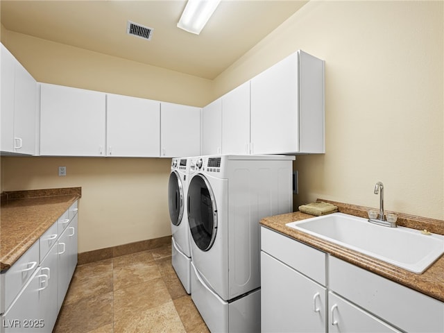 laundry area featuring baseboards, visible vents, cabinet space, a sink, and washing machine and dryer