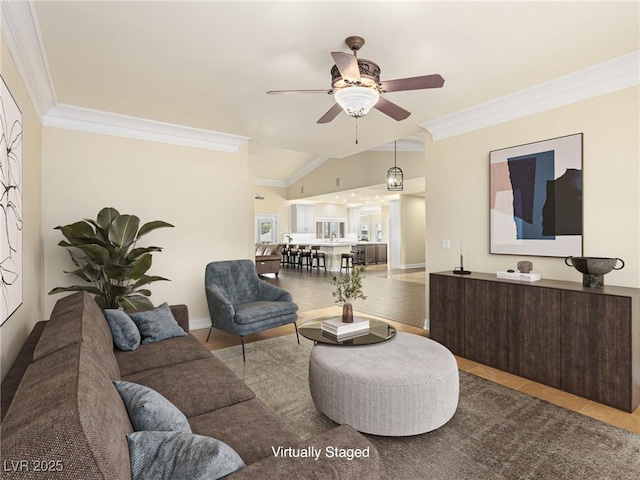 living room featuring ceiling fan, lofted ceiling, baseboards, and ornamental molding