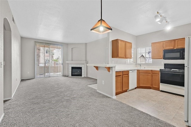 kitchen with white appliances, a textured ceiling, light colored carpet, open floor plan, and a wealth of natural light