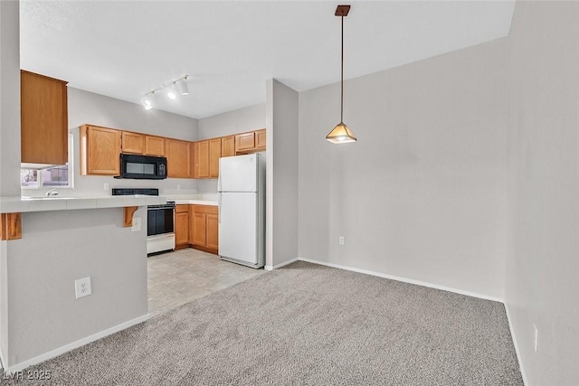 kitchen featuring black microwave, light colored carpet, range with electric stovetop, a peninsula, and freestanding refrigerator