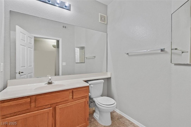 bathroom featuring visible vents, toilet, vanity, and baseboards