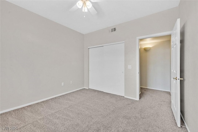 unfurnished bedroom featuring visible vents, a closet, carpet floors, baseboards, and ceiling fan