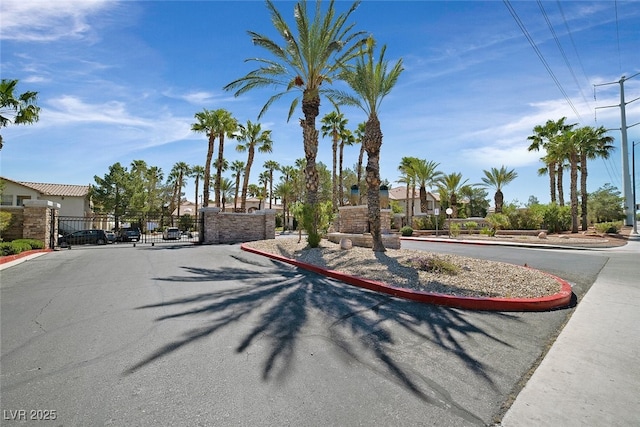 view of road with a gated entry, curbs, and a gate