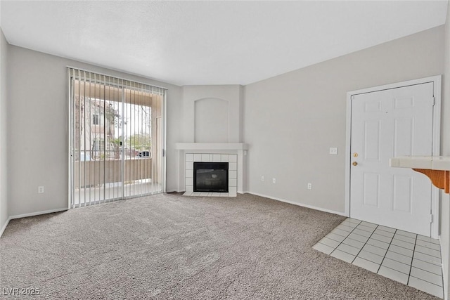 unfurnished living room with baseboards, carpet, and a fireplace