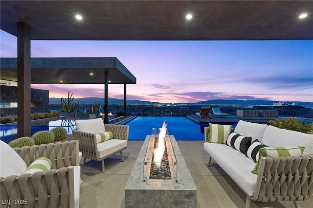 11 Cloud Chaser Blvd, Henderson, NV 89012 - patio terrace at dusk featuring an outdoor living space with a fire pit, a water view, and an outdoor pool