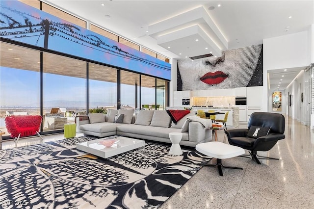 living area featuring speckled floor and a high ceiling