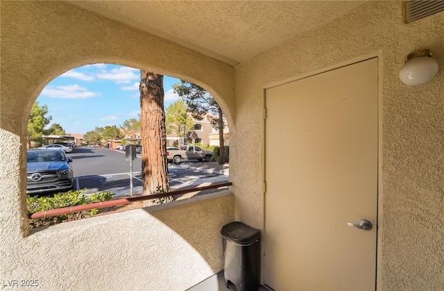 exterior space featuring visible vents, a residential view, and stucco siding