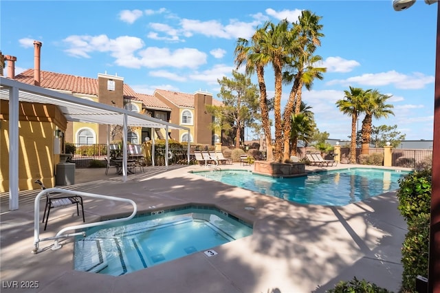 community pool with a community hot tub, fence, and a patio