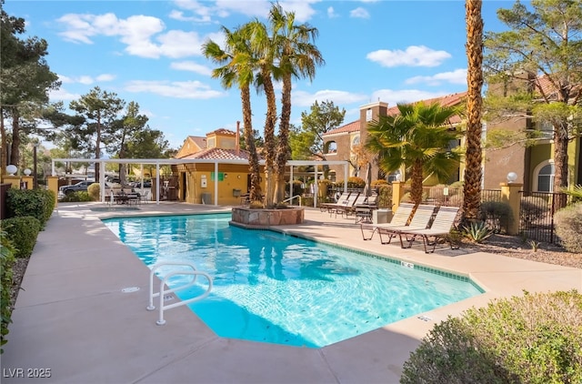 community pool with a patio area and fence