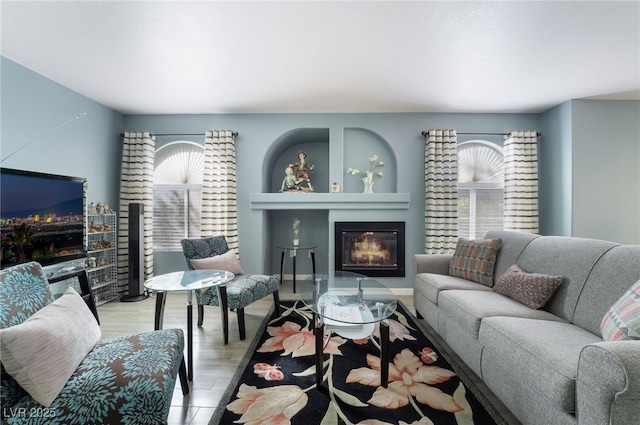 living area with a glass covered fireplace and wood finished floors