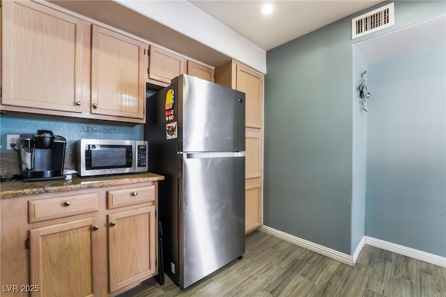 kitchen with visible vents, appliances with stainless steel finishes, wood finished floors, and light brown cabinetry