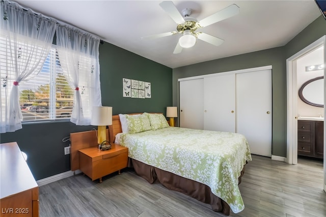 bedroom with ceiling fan, baseboards, a closet, and wood finished floors