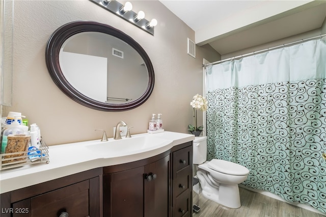 bathroom with visible vents, vanity, toilet, and wood finished floors