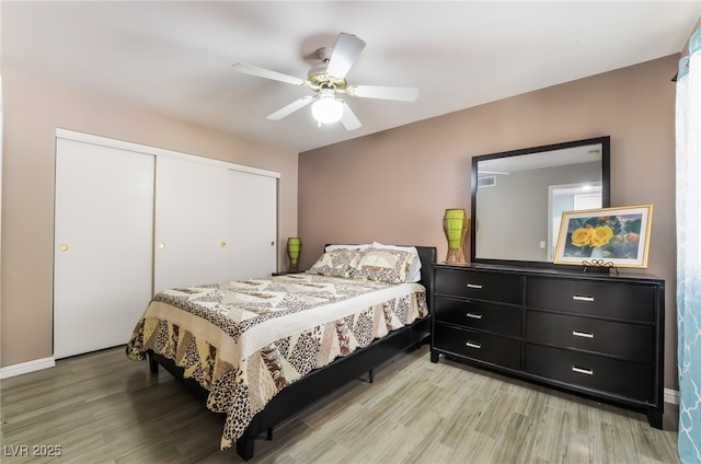 bedroom with visible vents, a closet, light wood-style flooring, and a ceiling fan